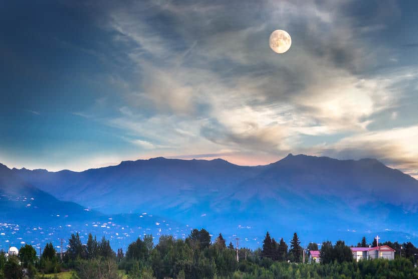 Full moon and mountains near by the Port Of Anchorage in Alaska, USA.